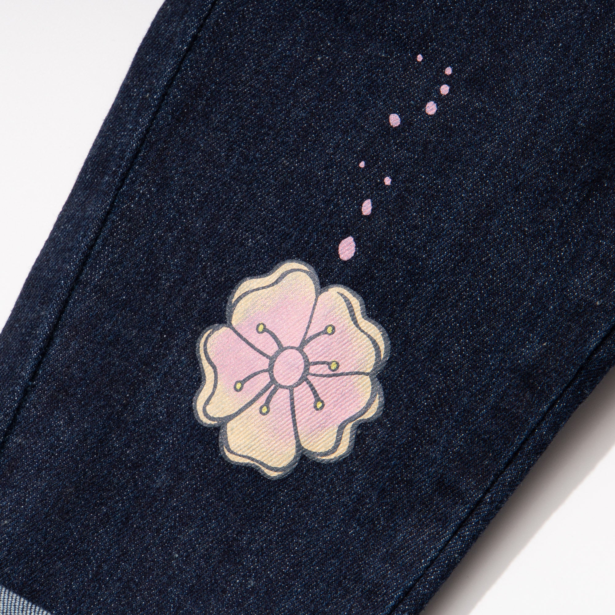 Indigo black jeans for girls, floral embossed prints above the hem and below the waist. A denim ribbon tie on waistband. Two front pockets included.Elasticated.  