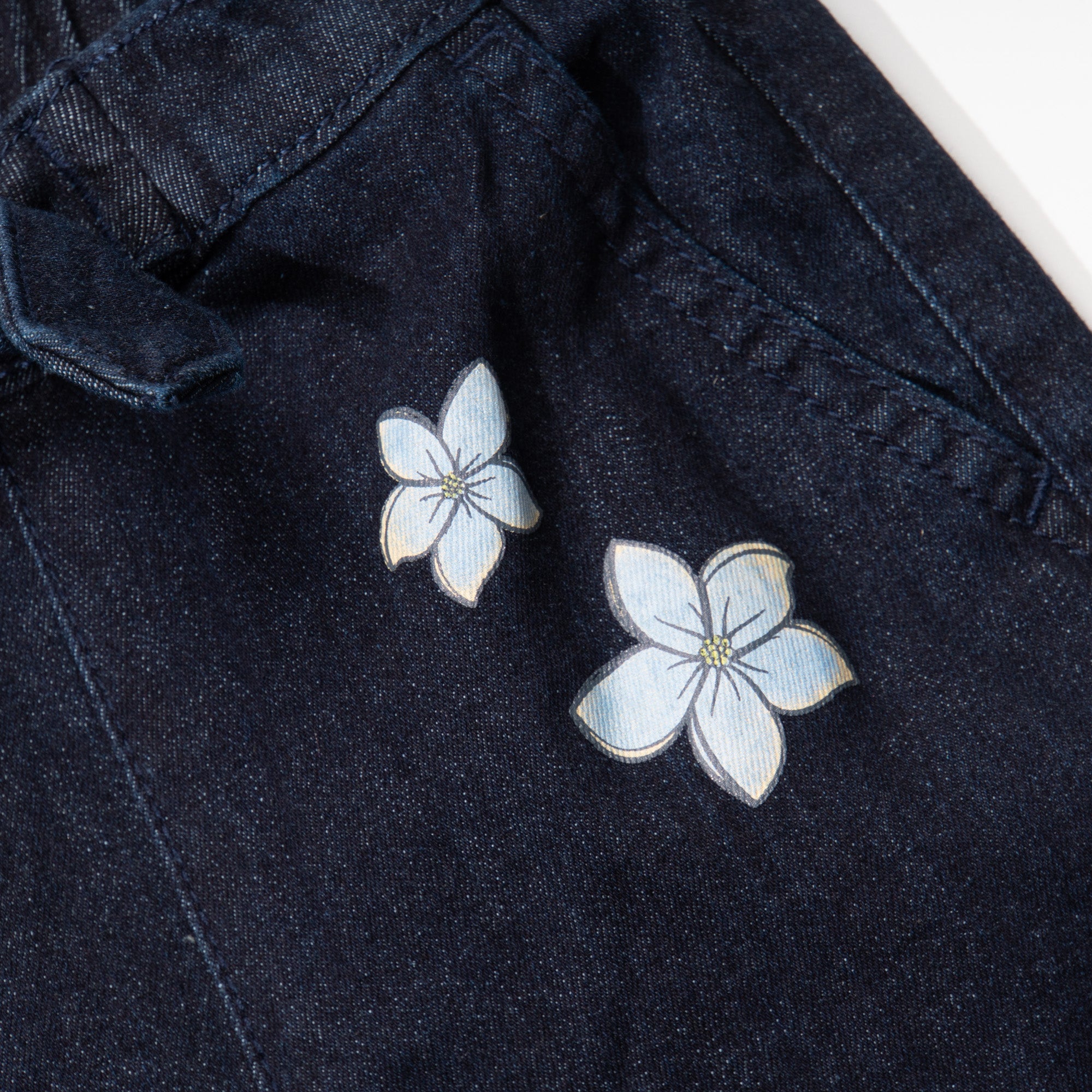 Indigo black jeans for girls, floral embossed prints above the hem and below the waist. A denim ribbon tie on waistband. Two front pockets included.Elasticated.  