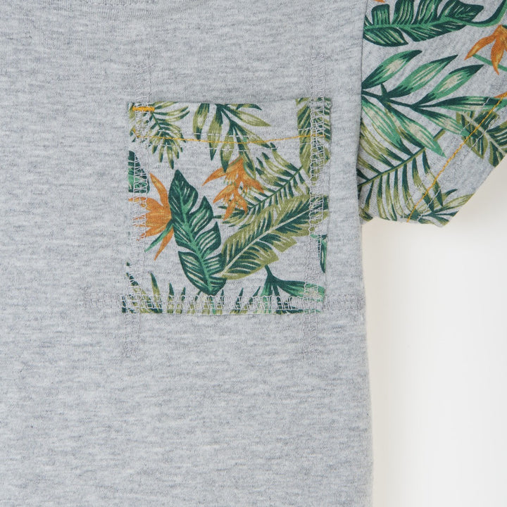 Melange top, short sleeve, beautiful tropical leaves design on sleeves and pocket. Buttoned shoulder strap, a logo strap on the bottom. 