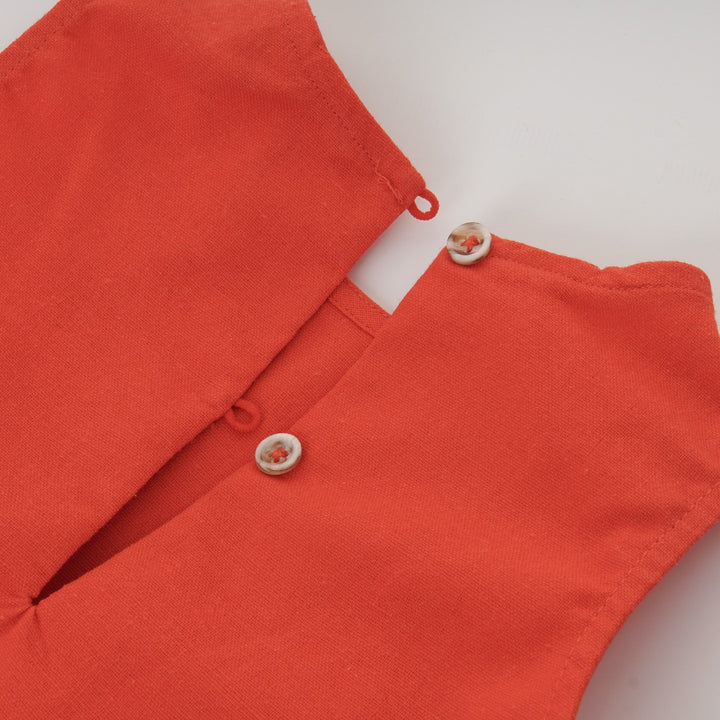 Red sleeveless blouse, fancy large bow. Back fastened by two buttons. 