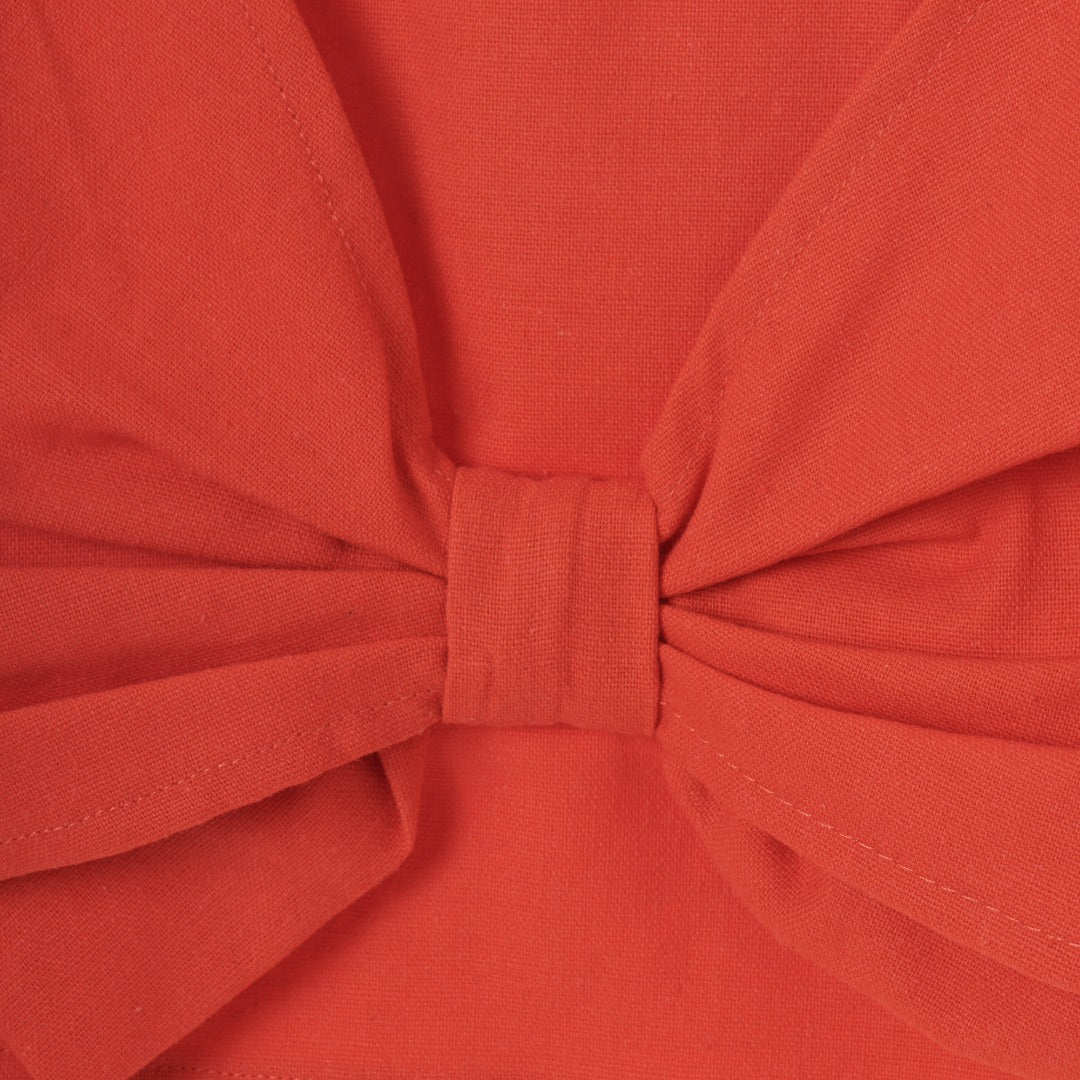 Red sleeveless blouse, fancy large bow. Back fastened by two buttons. 