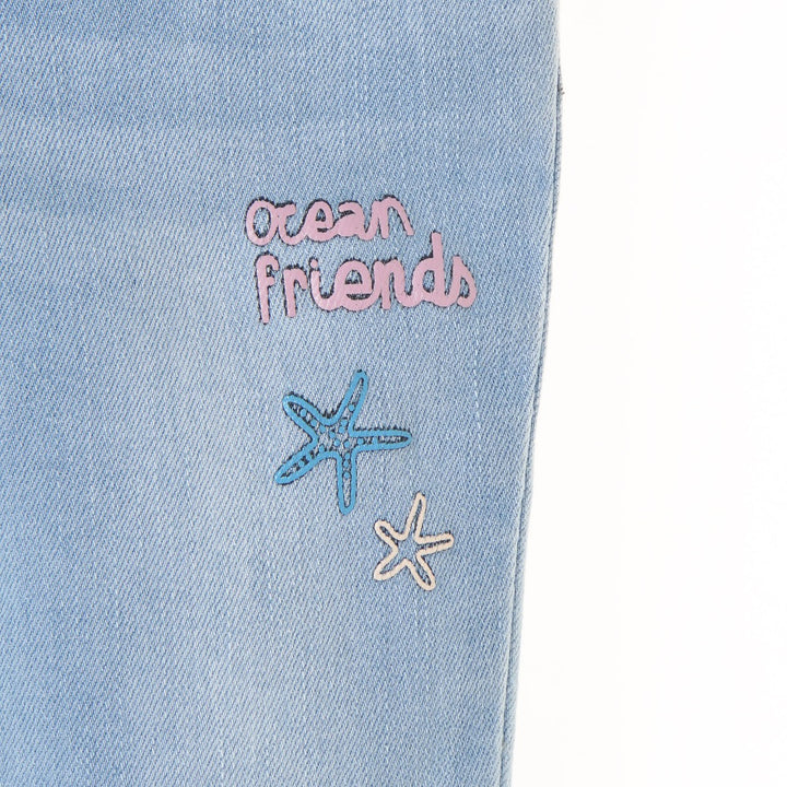 Slightly distressed, faded, embroidered, embossed, denim for girls with an ocean theme. Waistband Adjustments, front button/zipper fastening included. 