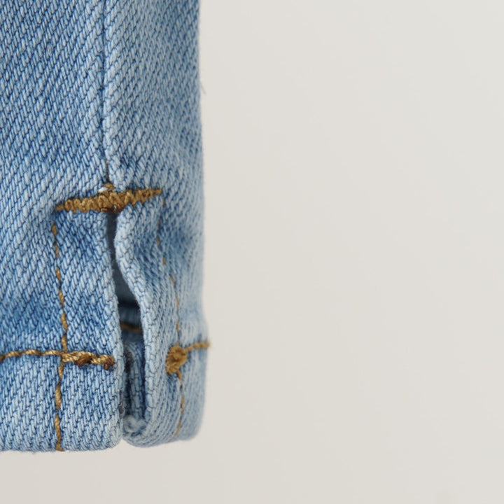 Smart, traditional, slightly distressed denim with front button/zipper fastening. Front and back pockets included, stitched slit hem at the bottom. 