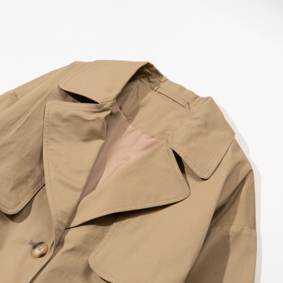 A khaki caped coat. Two buttoned pockets included as well as three fastening faded buttons at the front. 