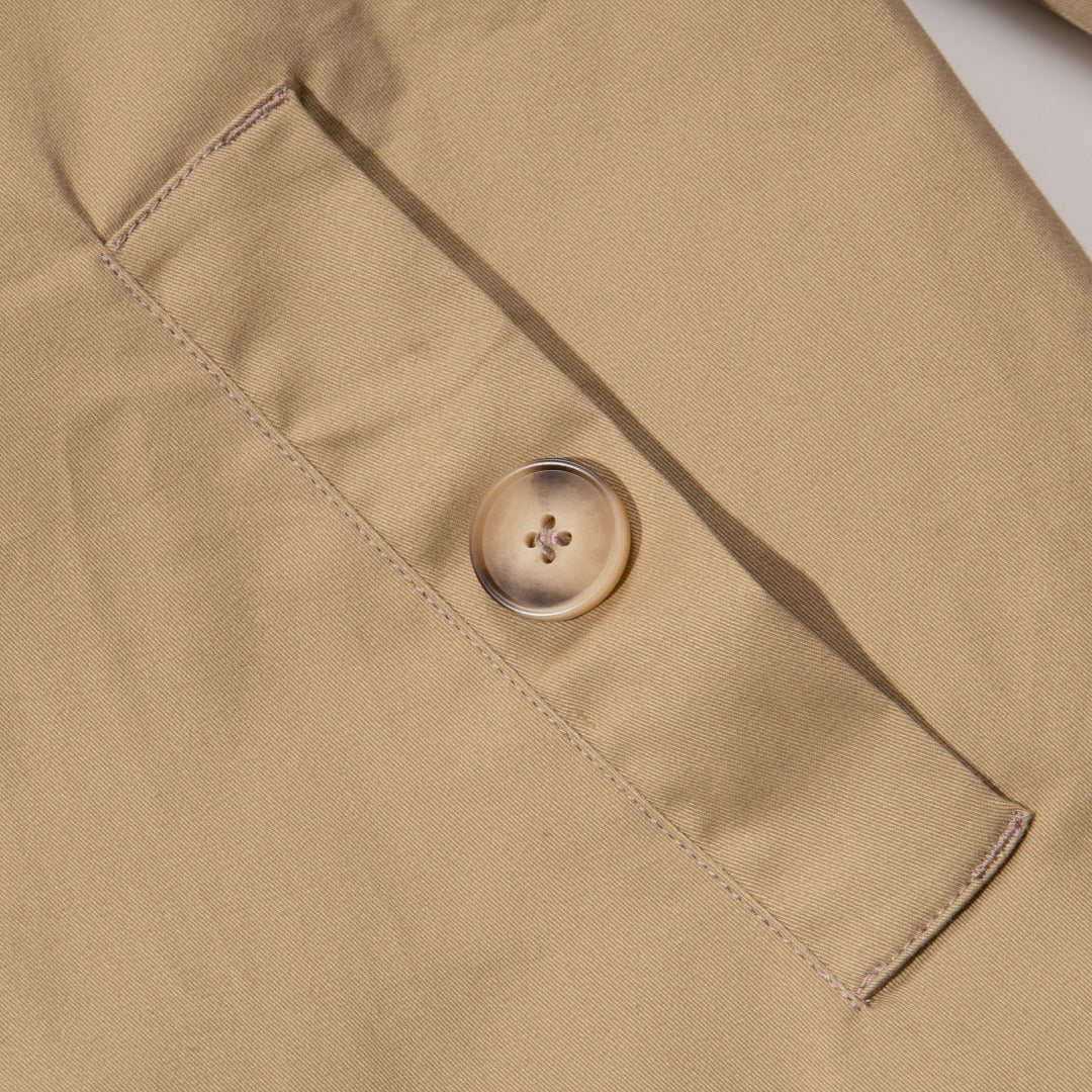 A khaki caped coat. Two buttoned pockets included as well as three fastening faded buttons at the front. 