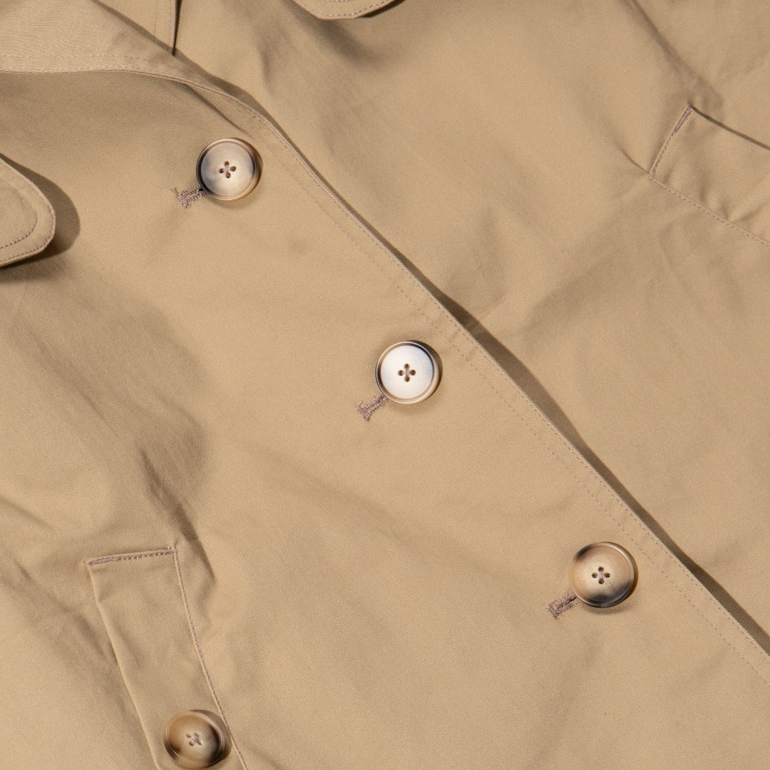 A khaki caped coat. Two buttoned pockets included as well as three fastening faded buttons at the front. 